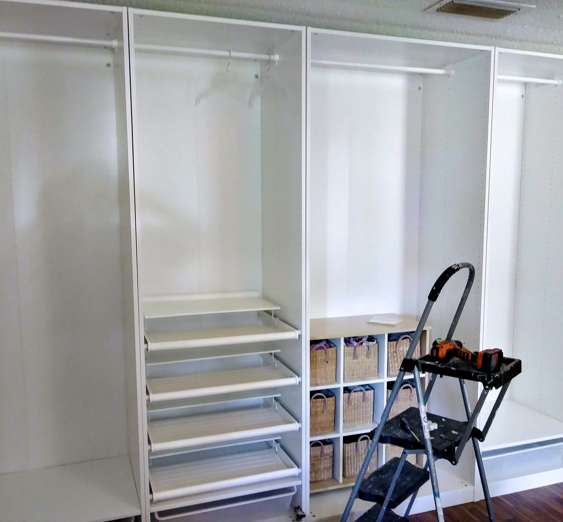 Custom closet with white shelving, hanging storage, shoes, and folded clothing