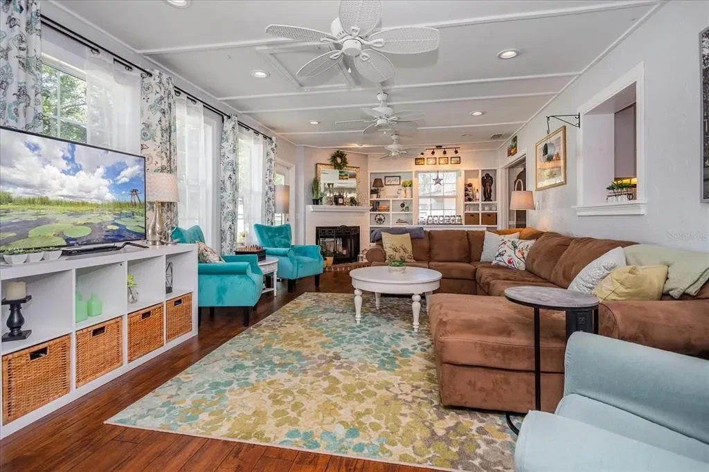 Family room with white seating, warm wood floors, and styled accents