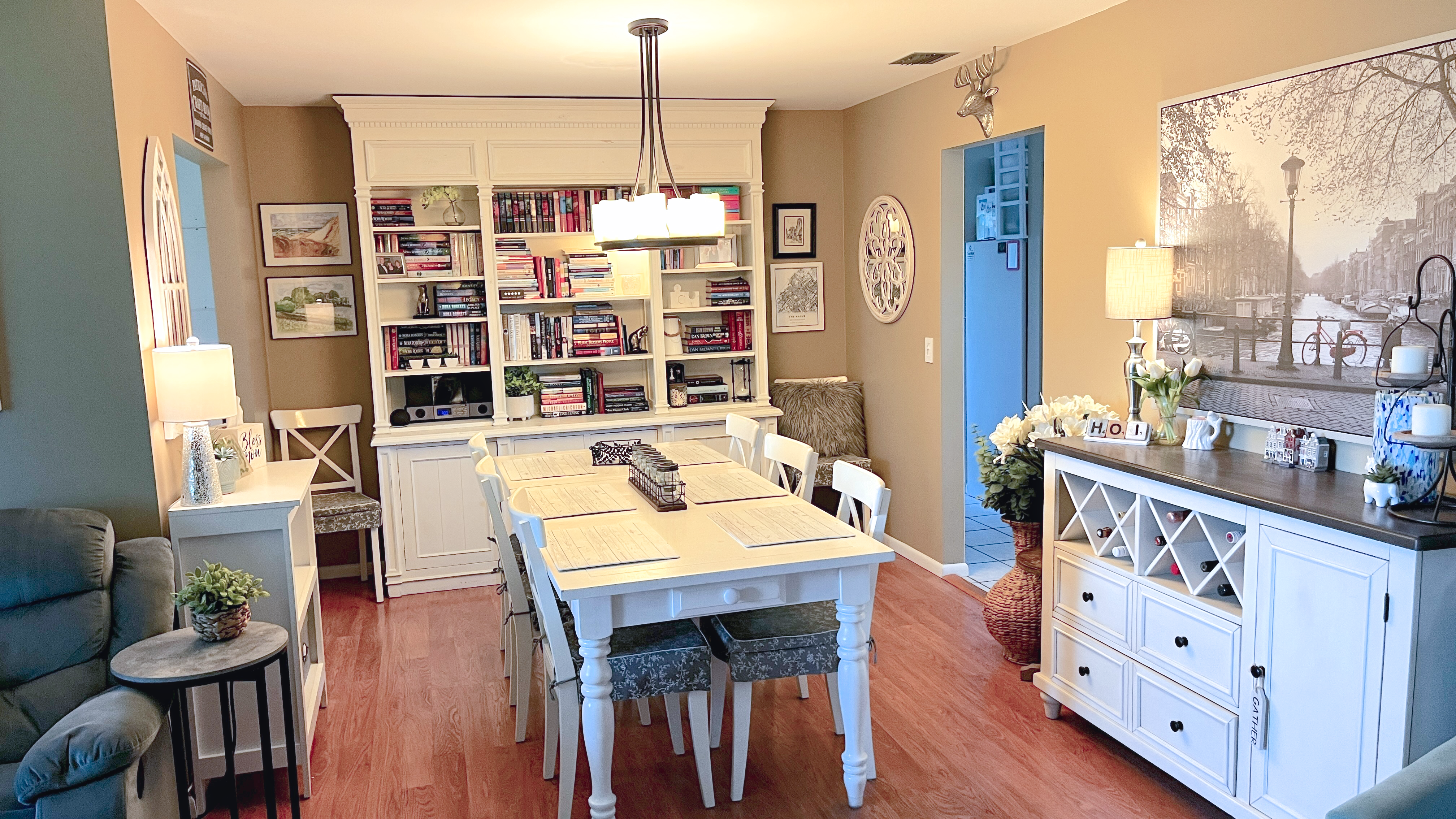 Dining area with white table, built-in bookcases, and coordinated sideboard