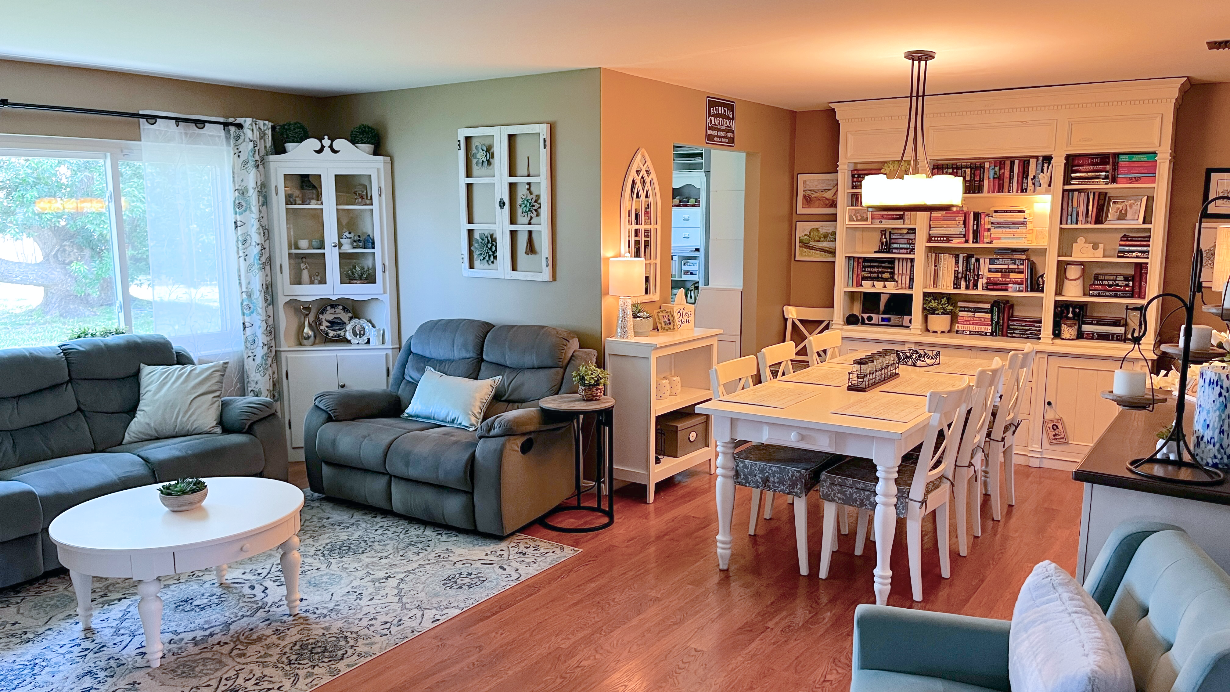 Connected living and dining room with white furniture and built-in bookcases