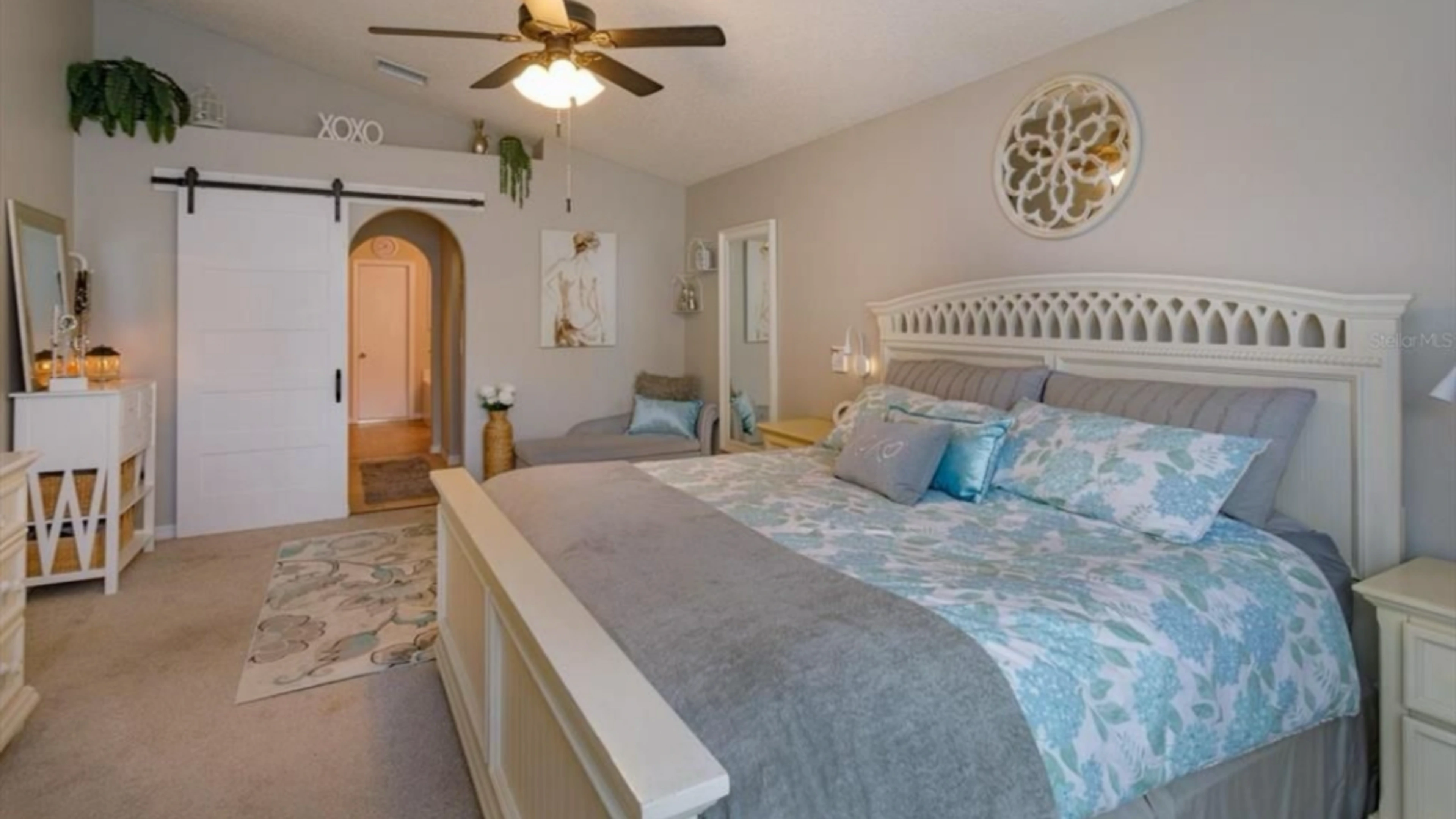 Primary bedroom with soft bedding and tidy styling
